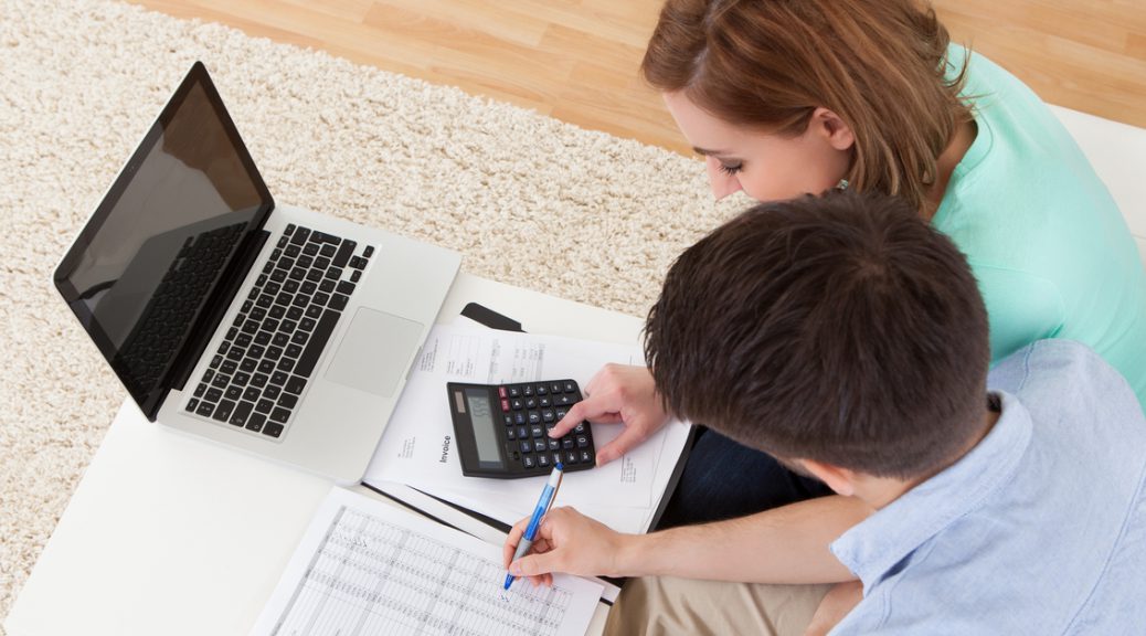 Portrait of young happy couple calculating budget