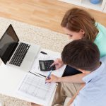 Portrait of young happy couple calculating budget