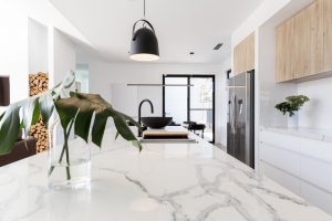 Kitchen marble bench close up with black hanging pendant and vas