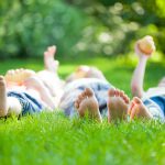 Family playing on green grass in spring park