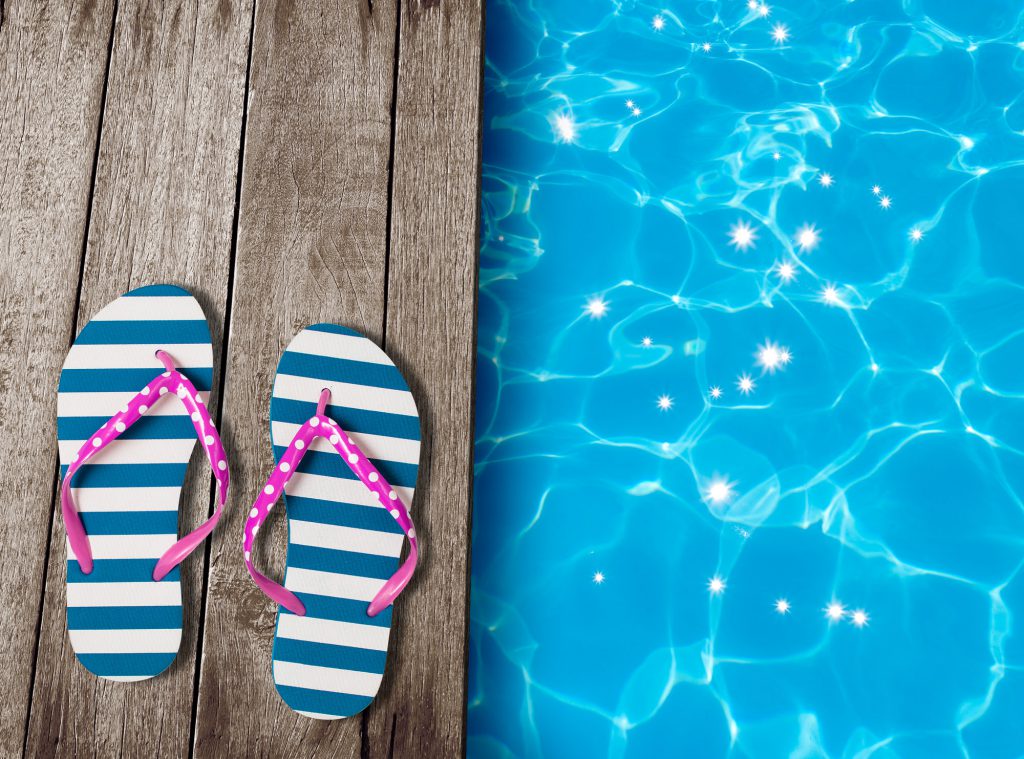 flip flop sandals on old wooden boards near swimming pool