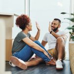 Shot of a young couple giving each other a high five while moving house