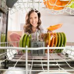 Happy Woman Removing Plate View From Inside The Dishwasher