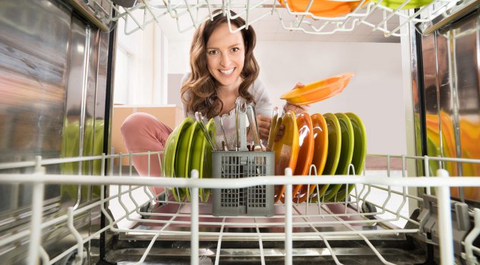 Happy Woman Removing Plate View From Inside The Dishwasher
